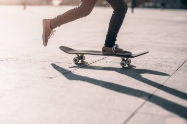 Şehir merkezinde gün batımında kadın kaykaycılığın alçak kesimi