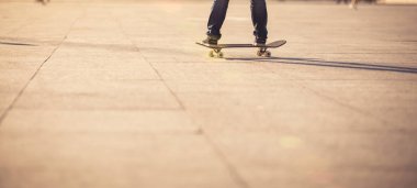 Şehir merkezinde gün batımında kadın kaykaycılığın alçak kesimi