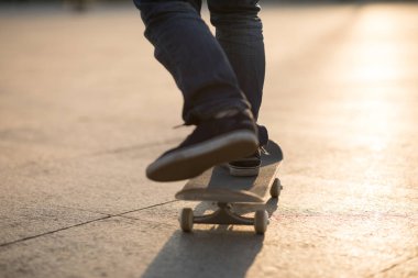 Çin 'de gün batımında kaykaycı parkında kaykay yapıyor.
