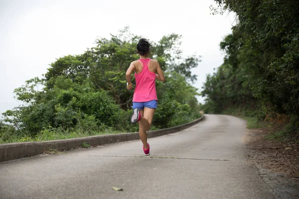 身材矮小的年轻女子穿着运动服在森林小径上奔跑 — 图库照片