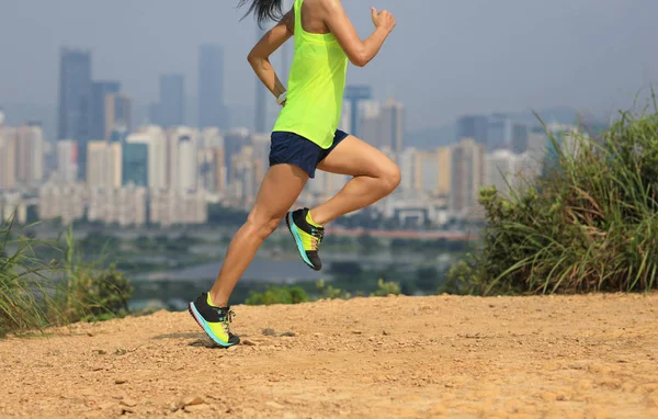 现代城市旁边山区的女超级马拉松选手训练 — 图库照片