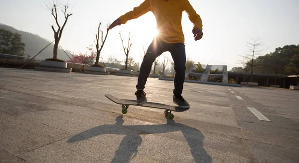 Unrecognizable woman skateboarding at sunset in urban Chinese city