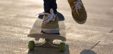 Gün batımında şehir parkı yolunda kaykaycı kadınların ayakları