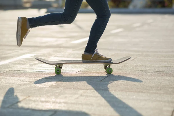 Poten Van Vrouwelijke Skateboarder Paardrijden Board Bij Stadsparkweg Bij Zonsondergang — Stockfoto