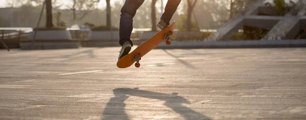 城市日出时女滑板手的腿 — 图库照片