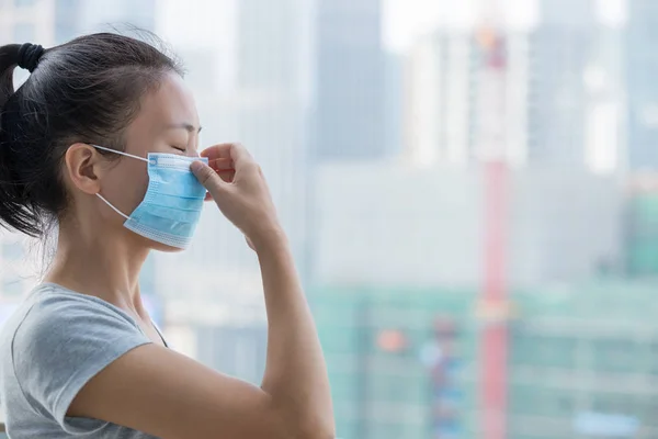 中国の都市でフェイスマスクを身に着けているアジアの女性の側面図 — ストック写真