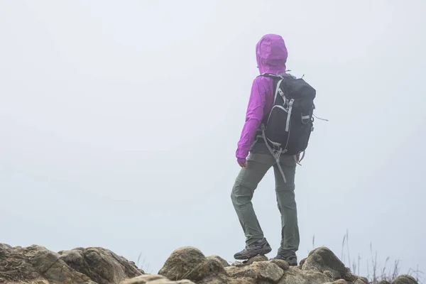 妇女在雾蒙蒙的山顶上登山 — 图库照片