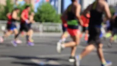 Şehir yolunda koşan kadın ve erkek maraton koşucularının bulanık görüntüleri, Shenzhen, Çin.