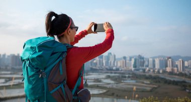 Çin 'in Shenzhen kentinin yanındaki balıkçı havuzlarının akıllı telefonuyla fotoğraf çeken kadın yürüyüşçü.
