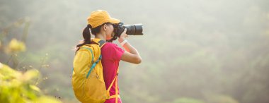 Sonbahar ormanında fotoğraf çeken kadın fotoğrafçı.