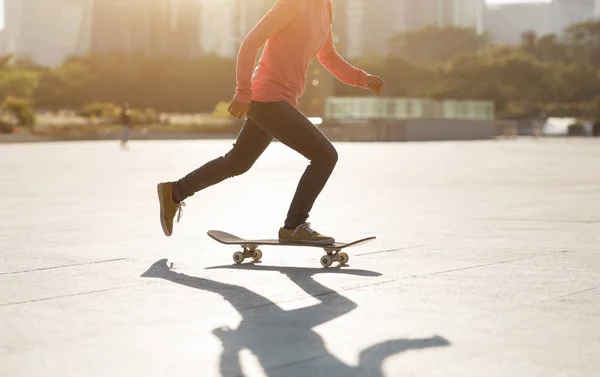 中国の都市のダウンタウンの日没で流行の女性スケータースケートボードのトリミング — ストック写真