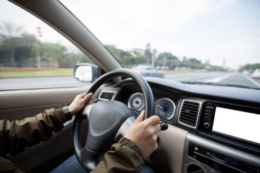 Şehir caddesinde araba süren kadının elleri