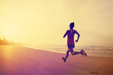 Gün doğumu plajda çalışan fitness kadın