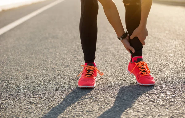 Injured Female Runner Touching Sprained Ankles — kuvapankkivalokuva