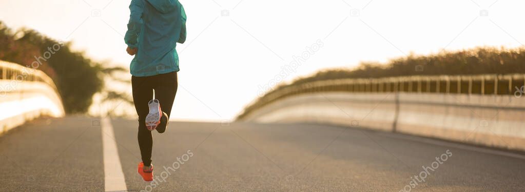 Fit woman running on urban city road