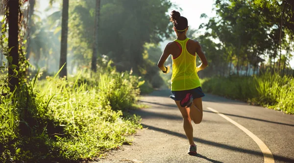 在热带森林小径上跑步的年轻健康妇女 — 图库照片