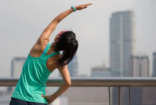 Healthy lifestyle woman stretching arms in foggy city