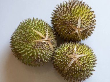 Düz arkaplanda üç durgun meyve