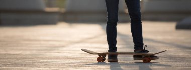 Parkta gün doğumunda kaykaycı bacakları