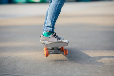 Kaykaycı dışarıda kaykayla numaralar yapıyor.