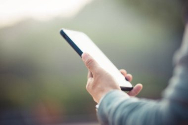 Asyalı kadın sabah dışarıda akıllı telefon kullanıyor.