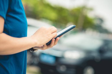Açık havada akıllı telefon kullanan Asyalı kadın.