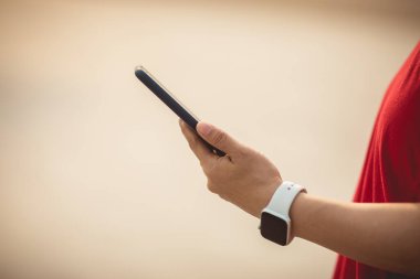 Açık havada dokunmatik ekranlı akıllı telefon kullanan eller