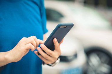 Açık havada akıllı telefon kullanan Asyalı kadın.