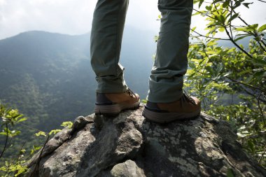 Başarılı yürüyüşçü dağın tepesindeki manzaranın tadını çıkar.