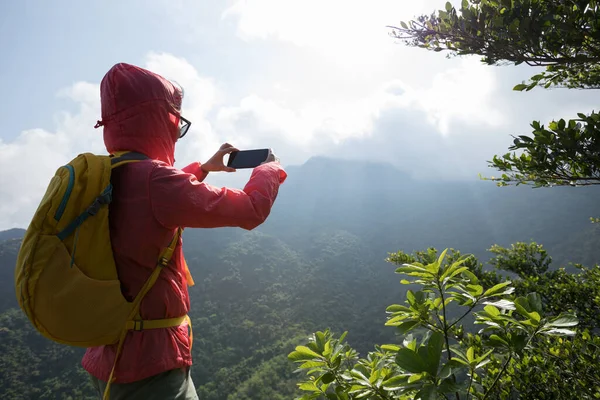 山の上でスマートフォンを使用して成功したハイカー — ストック写真