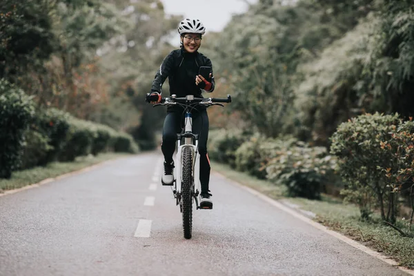 Bisikletçi Orman Yolunda Dağ Bisikleti Sürerken Akıllı Telefon Kullanır — Stok fotoğraf