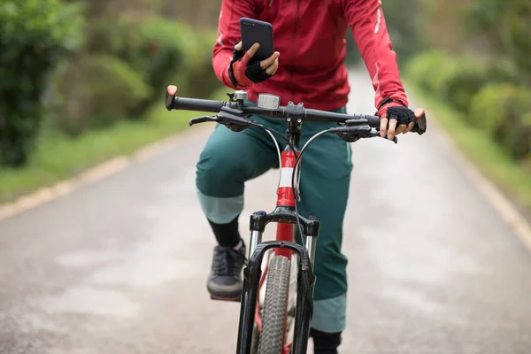 Bisikletçi Orman Yolunda Dağ Bisikleti Sürerken Akıllı Telefon Kullanır — Stok fotoğraf