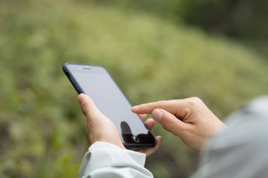 Bahar doğasında cep telefonu kullanan eller