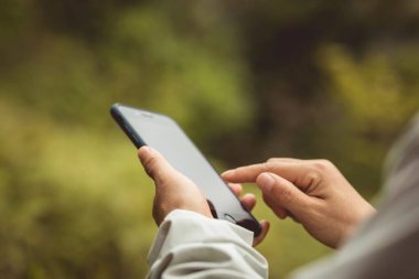 Bahar doğasında cep telefonu kullanan eller