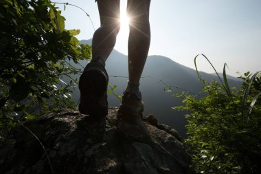 Başarılı bir yürüyüşçü yaz gündoğumu dağının zirvesinde yürüyüş yapıyor.