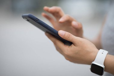 Eller sabah açık havada akıllı telefon kullanıyor.