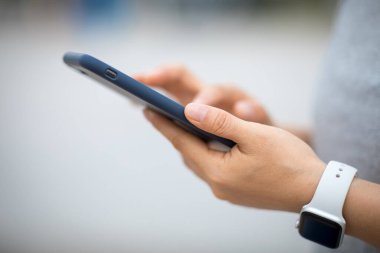 Eller sabah açık havada akıllı telefon kullanıyor.