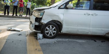 Trafik polisi ve şoför yol kenarındaki bir araba kazasıyla ilgileniyorlar.