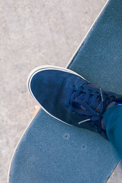 Skateboarder hand on blue skateboard at outdoors