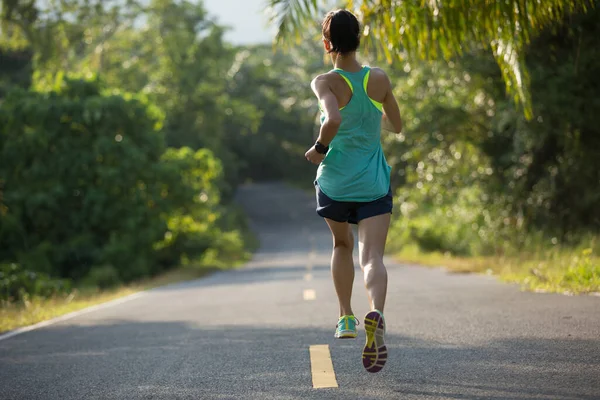 在热带森林小径上奔跑的年轻健康妇女 — 图库照片