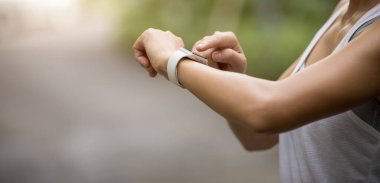 Dişi koşucu park yolunda koşmadan önce akıllı saatini ayarladı 