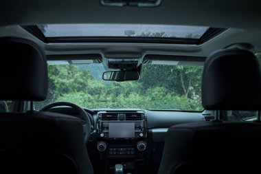 Luxury car interior in the rainy nature clipart