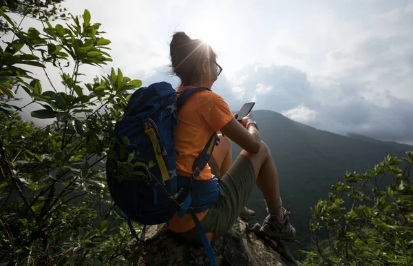 Gündoğumunda Dağın Tepesinde Akıllı Telefon Kullanan Başarılı Bir Yürüyüşçü — Stok fotoğraf