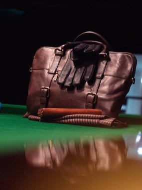 Kahverengi deri evrak çantası ve bilardo masasında siyah deri eldivenler.