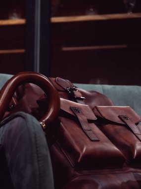 Kahverengi deri sırt çantası ve şemsiyeler.