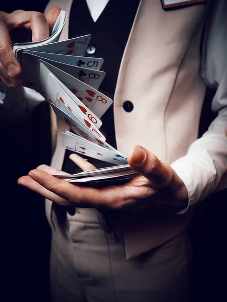 Een dealer in een casino houdt kaarten in zijn handen met een truc — Stockfoto