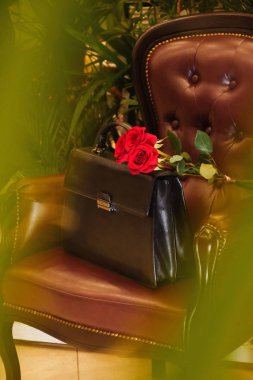 Kırmızı güllü siyah deri bir çanta.