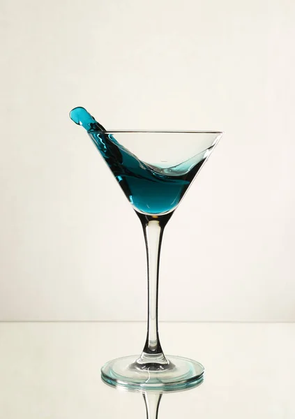 A splash of blue alcohol in a Martini glass — Stock Photo, Image