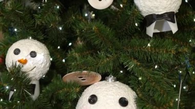 Ağaçta Noel süsleri var. Kardan adamın kafası ve düğmeleri..