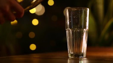 Şişeden bardağa su dök, yakın plan, arka plan bokeh